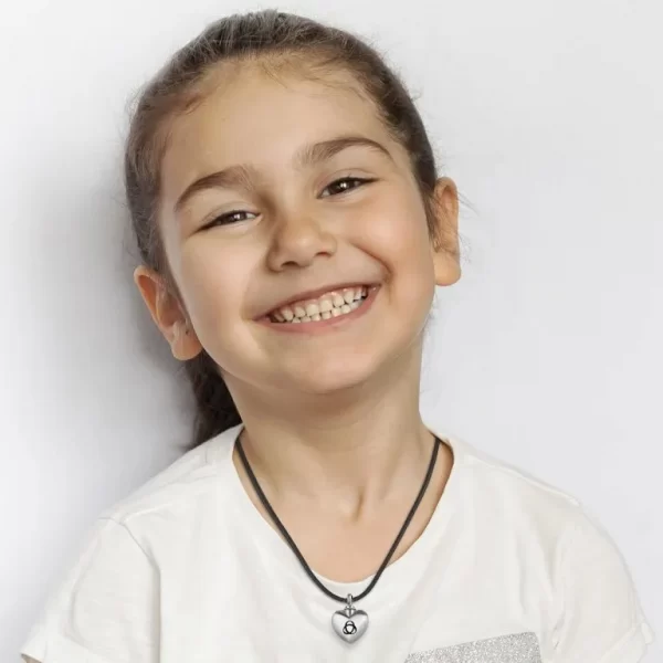 Smiling young girl wearing the Aulterra EMF Heart Pendant